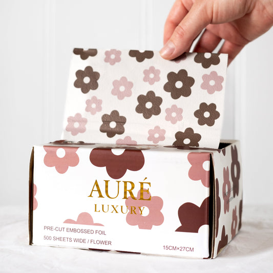 Hand holding a box of Aure Luxury pre-cut embossed hair foils design for salons in australia