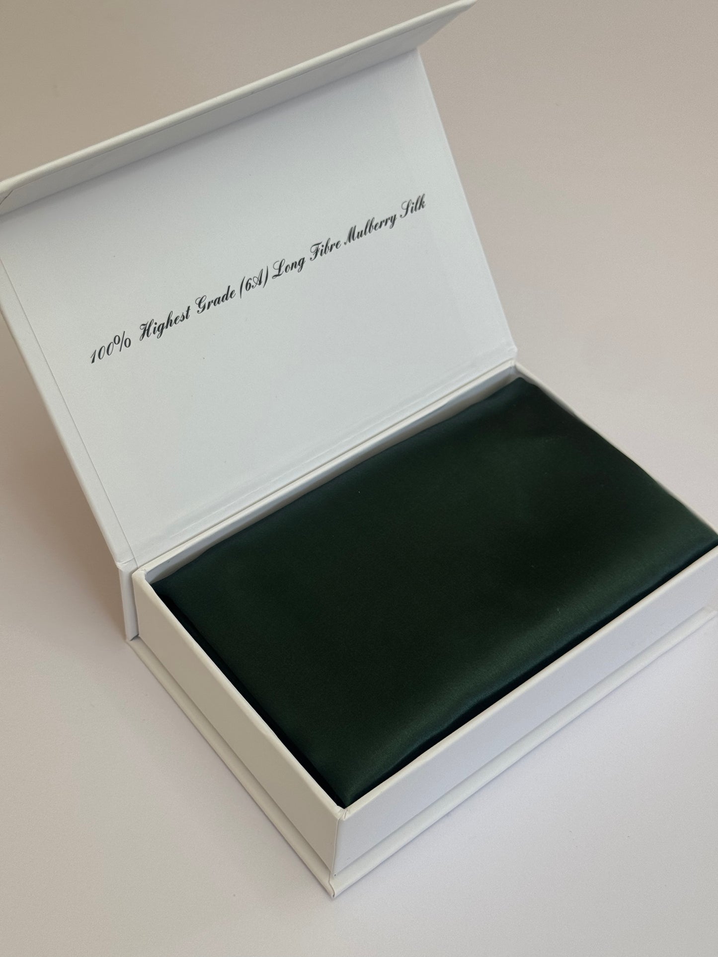 Open white box with a green interior on a light beige background